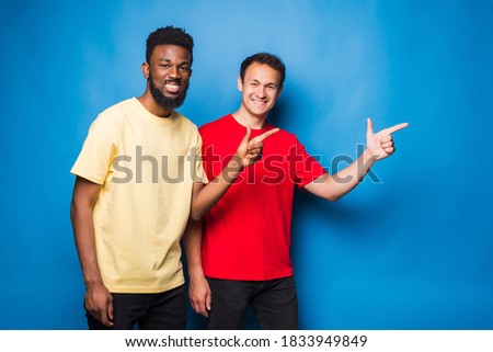 Two mixed race men pointed side on blue background