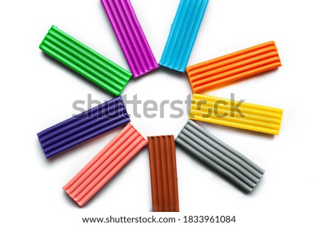 multi-colored plasticine on a white background is located in a circle