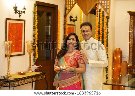 Couple in tradional wear at home in standing pose Royalty-Free Stock Photo #1833965716