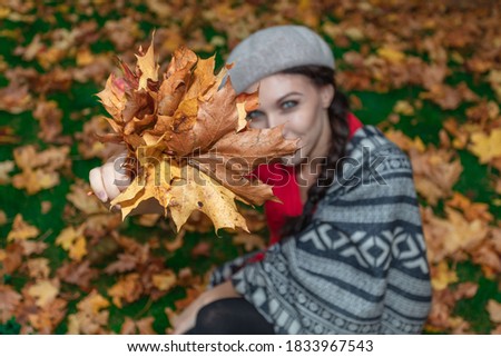 Woman holding a bouquet with maple leaves in her hands Autumn concept.
