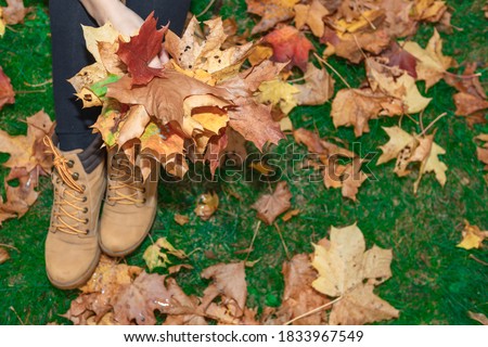 Woman holding a bouquet with maple leaves in her hands Autumn concept.