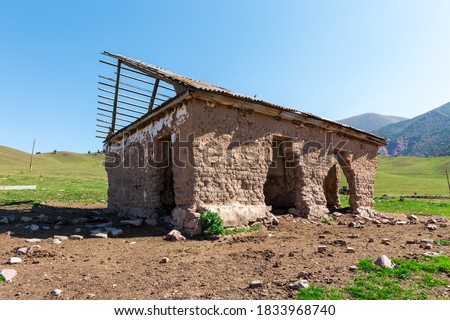 An old abandoned house. No people. The building is made of adobe and wood.