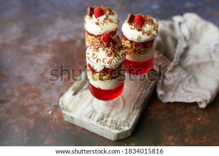 Dessert in a glass, raspberry jello with granola on yogurt and whipped topping   