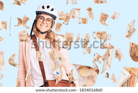 Young caucasian woman wearing bike helmet and leather bag looking positive and happy standing and smiling with a confident smile showing teeth