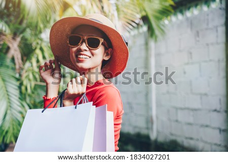 Young Asian woman carrying shopping bags, vintage films picture style.