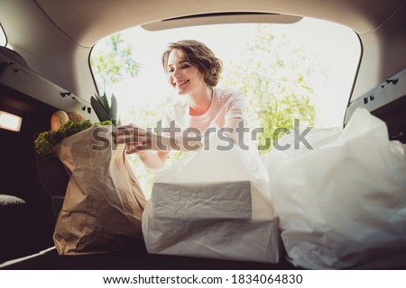 Photo of girl shopper put shopping bags in car trunk cabin ready ride drive home cook family husband meal in town center outside Royalty-Free Stock Photo #1834064830