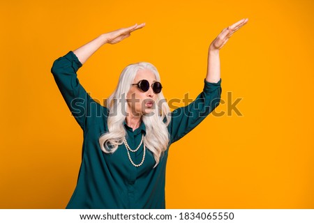 Photo of crazy funky grandma lady music lover senior retro party cool look dancing strange youngster moves wear green shirt sun specs necklace isolated bright yellow color background Royalty-Free Stock Photo #1834065550