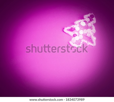 flat lay of white christmas tree wrapped in garland on neon-pink background with circular vignette and copy space