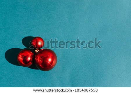 Three Christmas red shiny Christmas balls on a light siphon. Beautiful minimalistic Christmas background.