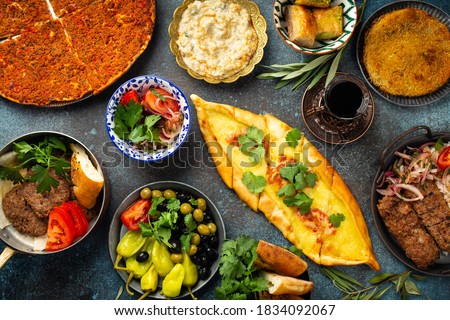 Traditional Turkish food, assorted dishes and mezze appetizers on rustic background from above. Pide, Lahmacun, meat kebab, Turkish meatballs, sweet baklava and Künefe. Middle East cuisine, top view 