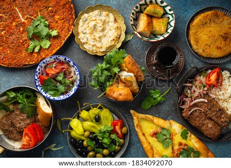 Traditional Turkish food, assorted dishes and mezze appetizers on rustic background from above. Pide, Lahmacun, meat kebab, Turkish meatballs, sweet baklava and Künefe. Middle East cuisine, top view 