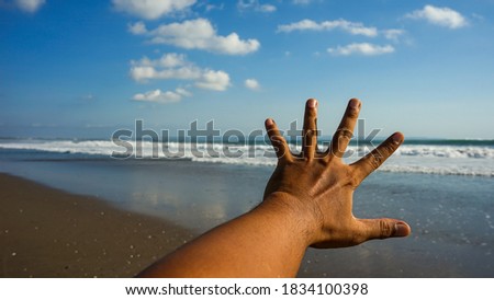 Male left hand with beach background
