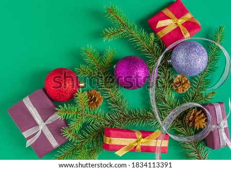  Christmas, New Year card - gifts, balls, spruce, cones on a green background. Flat lay, copy space, top view