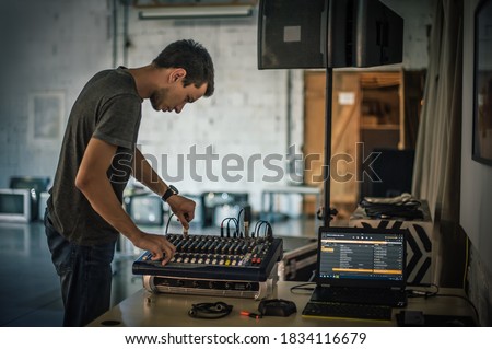Behind the scene. Sound technician electric engineer adjusting sound elements backstage. Control audio panel. Audio mixing console