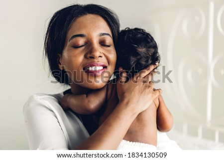 Portrait of enjoy happy love family african american mother playing with adorable little african american baby.Mom hug with cute son moments good time in a white bedroom.Love of black family concept