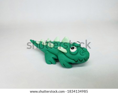 Plasticine statue a  Cute green little crocodile on white background.