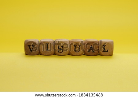 VISUAL Word Written In Wooden Cube With Yellow Background