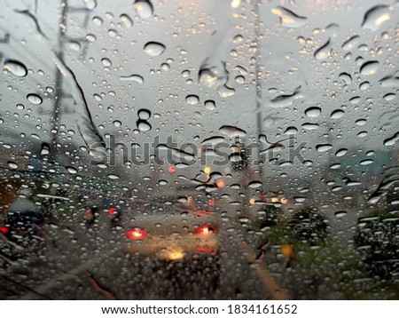 The rain drops on the windshield while driving through the rain.,with mobile