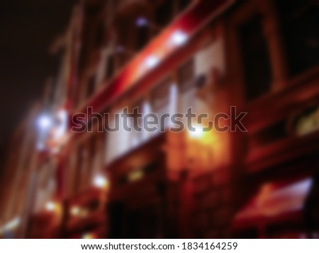 Defocused photography. Lights and bokeh on the street at christmas. Abstract dark blurry urban background.