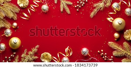 Golden Christmas balls and fir branch on red background