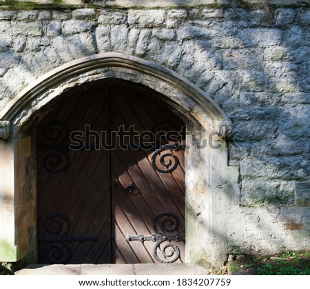 Creepy gothic wooden door with elaborate hinges 