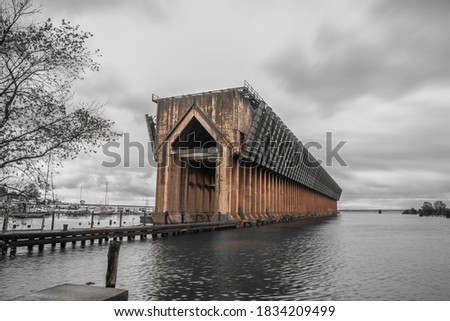 Abandoned old ore dock in lake Superior near Marquette city, in the past this large structure is used to transfer iron coal ore from rail road to ships. Monochrome shot with only ore dock in color.