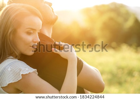 Couple lovers hugging and kissing in the park at sunset. Love, youth, happiness concept.