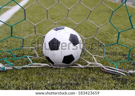 soccer football in goal net