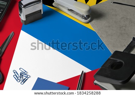Antigua and Barbuda flag with office clerk workplace background. National stationary concept with office tools.