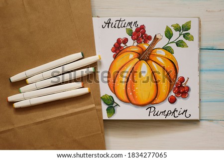 Autumn mood backstage with sketch with markers. Pumpkin with red berries
