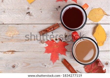 Autumn drink, seasonal composition, hot tea and coffee with cinnamon, mulled wine in iron mugs on wooden background, copy space, Happy thanksgiving concept, greeting card,