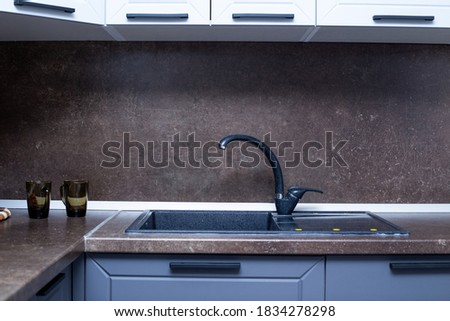 countertop with built-in sink made of black artificial stone, kitchen interior. Royalty-Free Stock Photo #1834278298