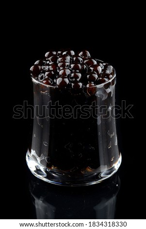 Black tapioca pearls for bubble tea, Bubble topping for tea or other beverage, in a cup . Copy space