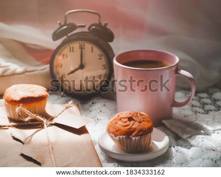 Pink Coffee mugs, snacks clock and gift box on white fabric background with sunlight.Top view. Coffee in morning holiday breakfast composition concept.