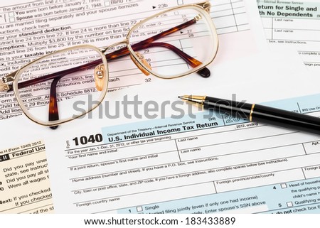 Tax form with pen and glasses taxation concept