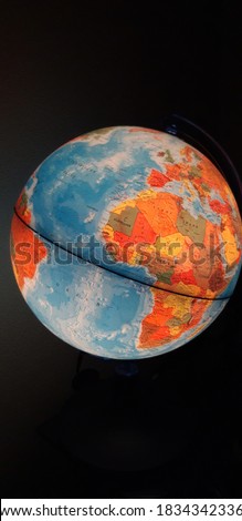 Picture of a lighted globe in a dark room that shows the continent Africa.