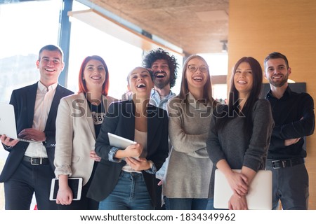 Portrait of successful creative business team looking at camera and smiling. Diverse business people standing together at startup.