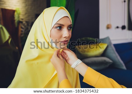 Portrait of a beautiful, elegant and attractive young Malay Asian Muslim woman in a dress and an hijab head scarf.