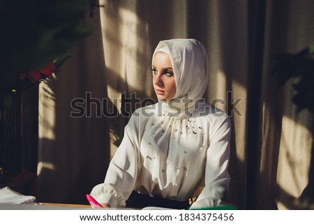 Portrait of a beautiful, elegant and attractive young Malay Asian Muslim woman in a dress and an hijab head scarf. Royalty-Free Stock Photo #1834375456