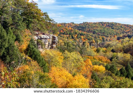 The southwestern Ohio autumn landscape is painted with the colors of fall leaves as viewed high above the trees and rock walls of Conkle’s Hollow in the beautiful Hocking Hills. Royalty-Free Stock Photo #1834396606