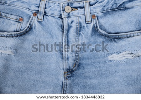 closeup pocket on blue denim torn  jean and button with texture

