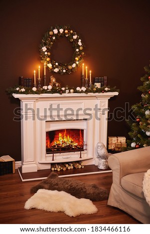 Christmas fireplace interior. Modern style interior of fireplace with christmas tree and gifts. Fireplace with lots of candles. Room Christmas Tree Fireplace Lights, vertical photo, Xmas Home Interior
