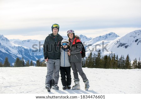 Family, skiing in winter ski resort on a sunny day, enjoying scenery landscape