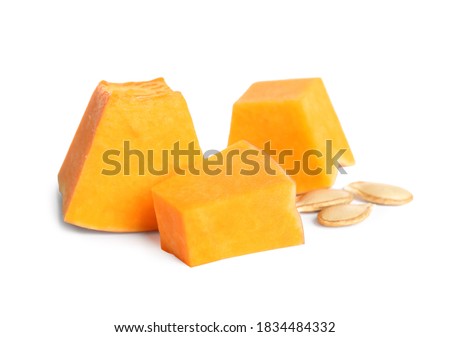 Pieces of ripe orange pumpkin and seeds on white background