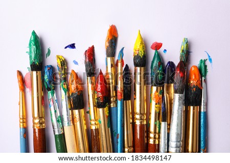 Brushes with colorful paints on white background, flat lay Royalty-Free Stock Photo #1834498147