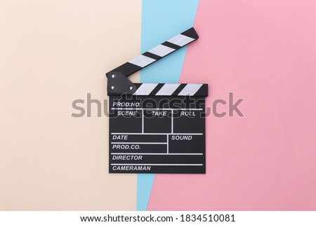 Movie clapper board on colored pastel background. Cinema industry, entertainment. Top view