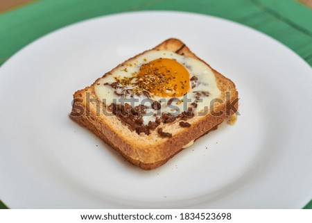 Sandwich on toast with minced meat, egg and seasonings.