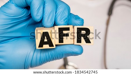 AFR Acute renal failure - word from wooden blocks with letters holding by a doctor's hands in medical protective gloves. Medical concept.
