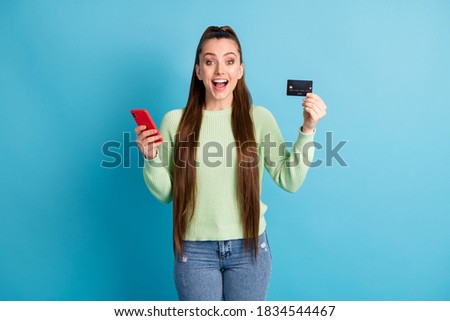 Photo portrait of screaming woman holding phone bank card isolated on pastel blue colored background