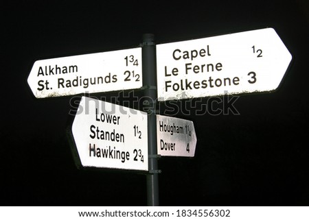 old English signpost with small towns on a coastal country road crossing